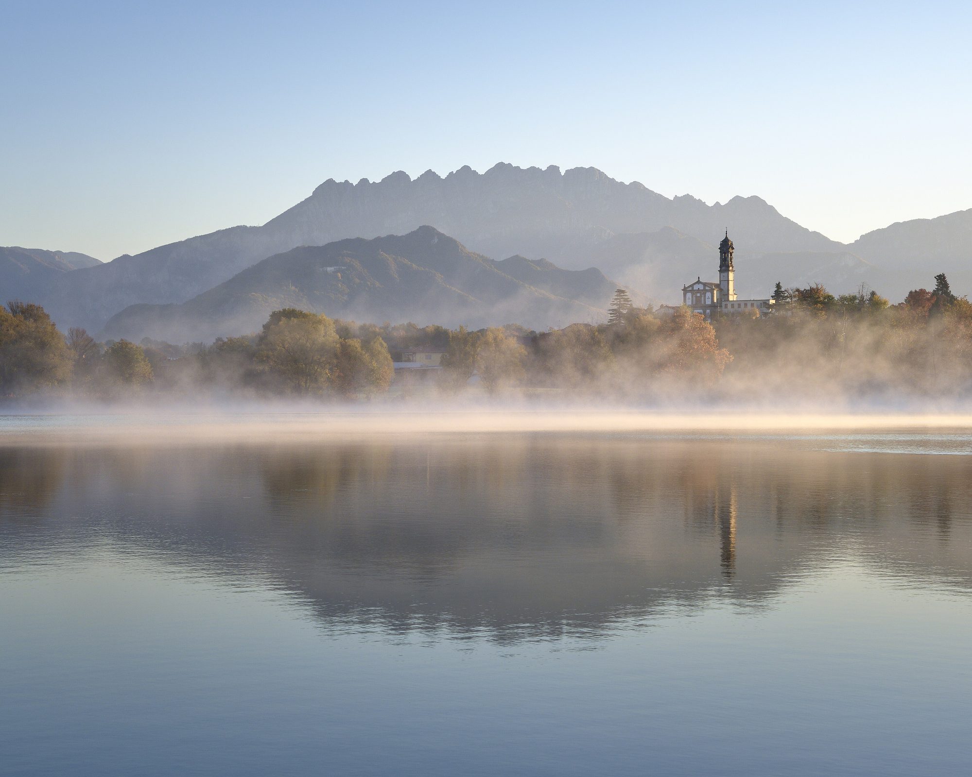 Nebbia mattutina sul lago di Pusiano con il Resegone sullo sfondo