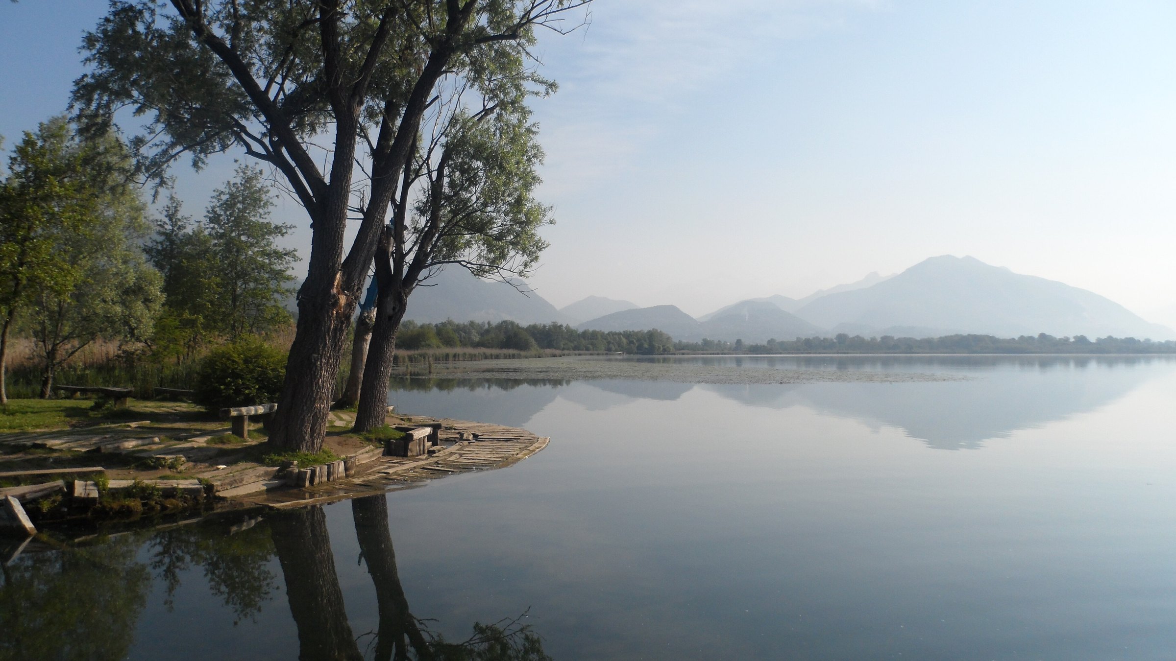 Il lago di Alserio all'alba, con le Prealpi e le Grigne riflesse nell'acqua ferma
